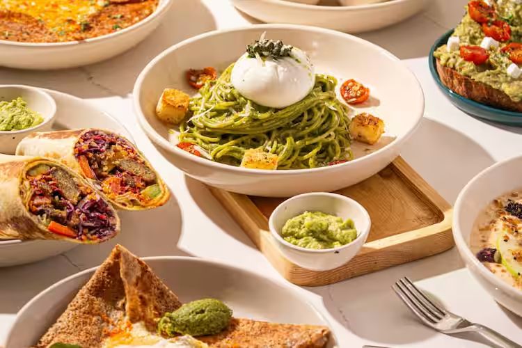 A table of fresh, colourful plated dishes
